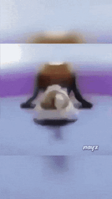 a blurred image of a person with the word nayx on the bottom left
