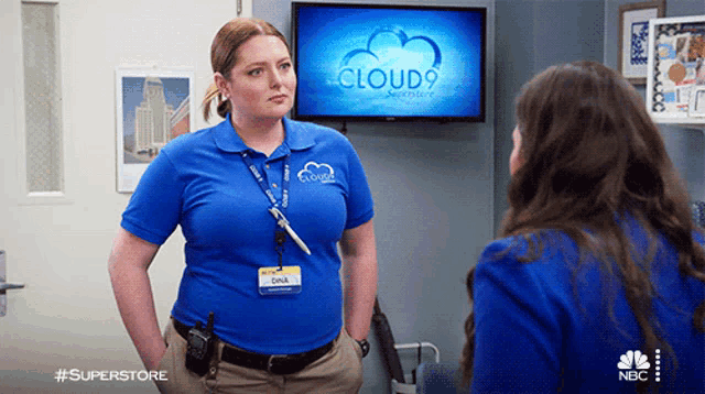 two women standing in front of a screen that says cloud9 on it