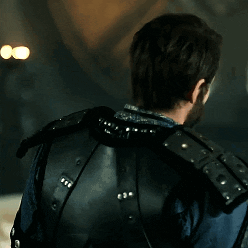 a man with a beard is wearing a blue and black armor