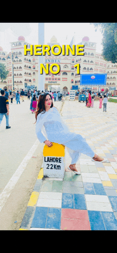 a woman sitting on a yellow sign that says lahore 22km