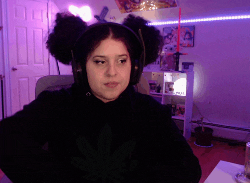 a woman wearing headphones and a marijuana leaf shirt