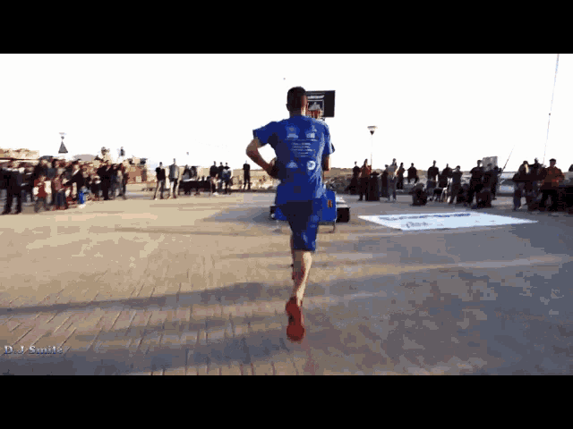 a man wearing a blue shirt with the letter d on it is running