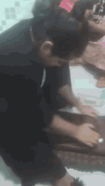 a man in a black shirt is kneeling down on a bed