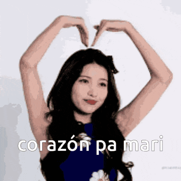 a woman is making a heart shape with her hands and the words corazon pa mari are below her