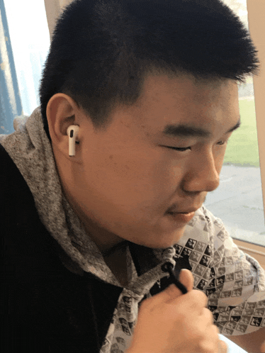 a man wearing a pair of white ear buds looks down