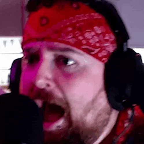 a close up of a man wearing headphones and a red bandana .