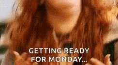 a woman with red hair is getting ready for monday with her hands in the air .