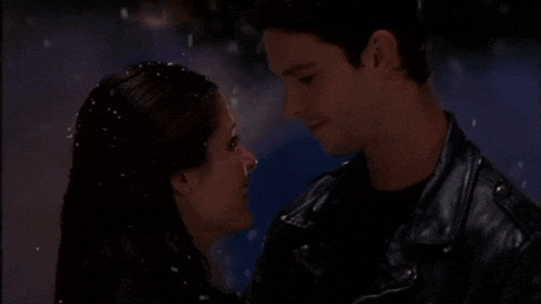 a man and a woman are looking at each other in the snow