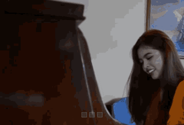 a woman is playing a piano in front of a painting on the wall