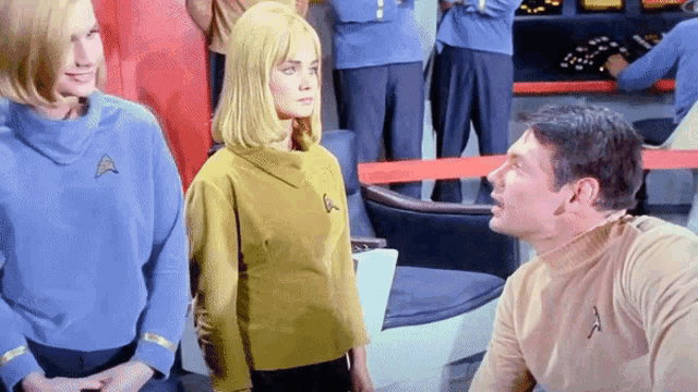 a man in a star trek uniform talks to a woman