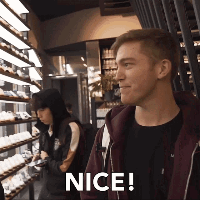 a man in a maroon hoodie says nice in a store