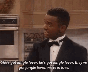 a man in a tuxedo is talking to another man in a kitchen while wearing a bow tie .