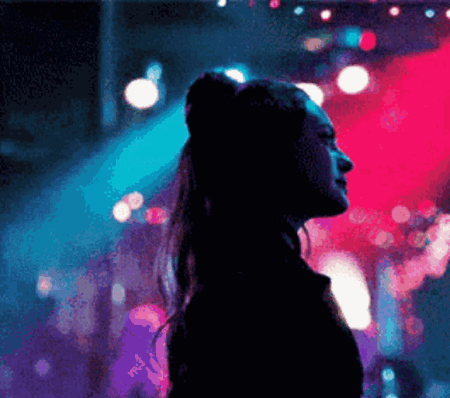 a silhouette of a woman standing in front of a red and blue light