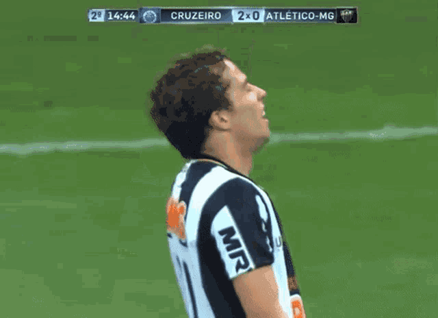a soccer player wearing a bmg jersey stands on a field