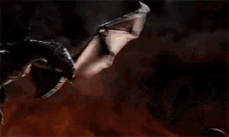 a dragon is flying through the air in a dark room surrounded by fire .