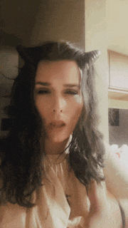 a woman with long dark hair wearing cat ears