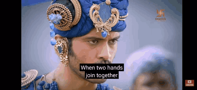 a man is wearing a blue turban and earrings and says when two hands join together