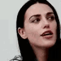 a close up of a woman 's face with her mouth open against a white background .