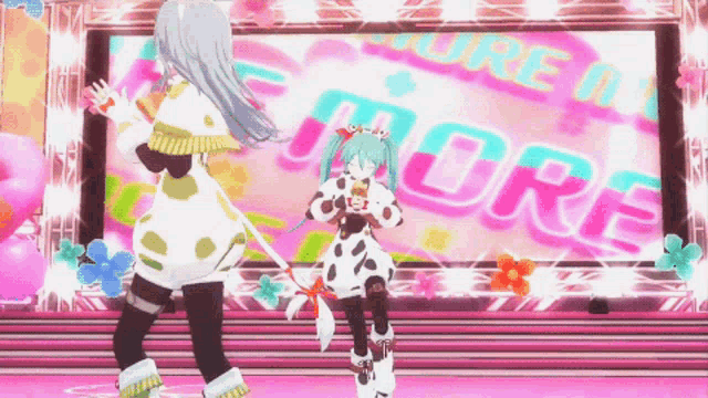 two anime girls are dancing in front of a large screen that says more