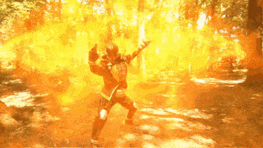 a man in a superhero costume is surrounded by flames in a forest