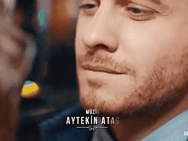 a close up of a man 's face with the name aytekin atas on the bottom right