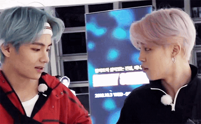 two men are looking at each other in front of a sign that says ' wed ' on it