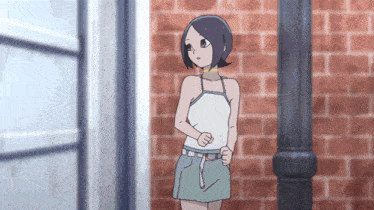 a girl standing in front of a brick wall