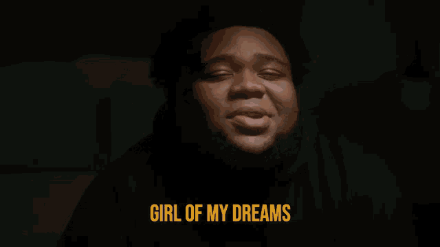 a man in a black hoodie says girl of my dreams in yellow letters
