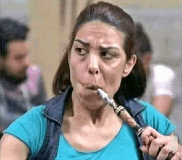 a woman is smoking a hookah in a blue shirt .