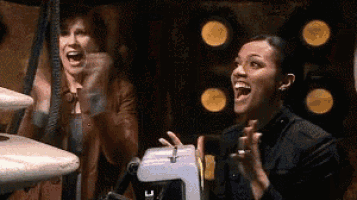 two women are laughing in front of a sewing machine with the letter c on it