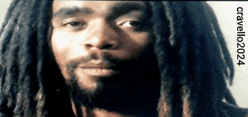a close up of a man with dreadlocks and a beard with the year 2024 on the bottom