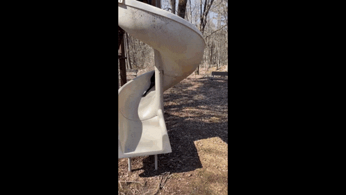 two dogs are playing in a playground with a white slide .