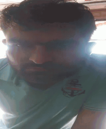 a man with a beard wearing a blue shirt with an anchor on it
