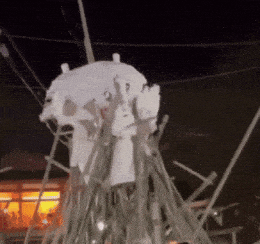 a jellyfish made out of branches is hanging from a pole