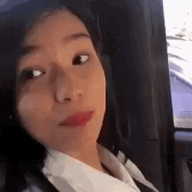a close up of a woman 's face in a car looking at the camera .