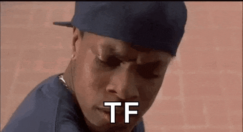 a man wearing a hat and a blue shirt is making a funny face .