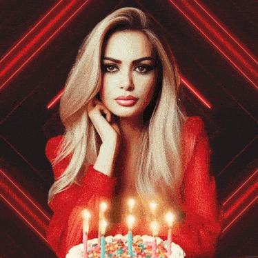 a woman in a red dress sitting in front of a birthday cake with candles