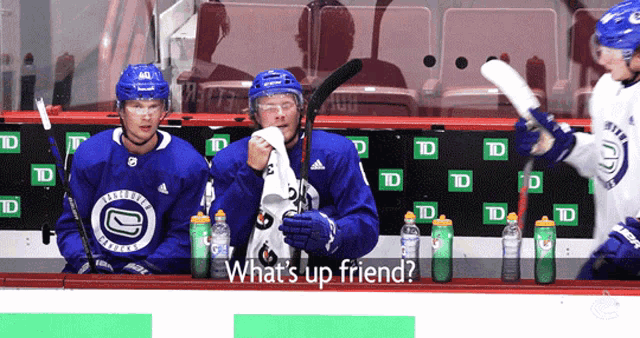 three hockey players are sitting on the bench with the words " what 's up friend " on the bottom