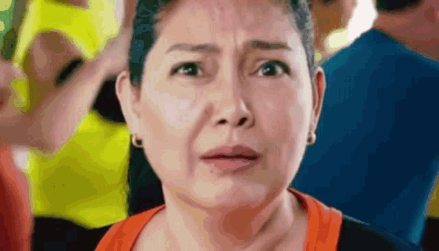 a close up of a woman 's face with a crowd behind her