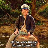 a young boy is riding on the back of an elephant in the water .