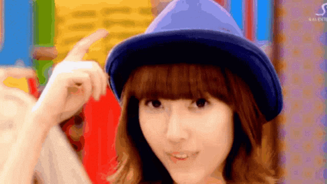 a woman wearing a blue hat with the letter s in the corner