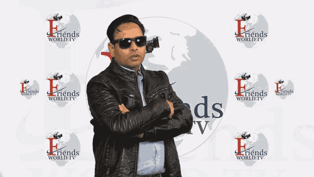 a man stands in front of a friends world tv logo