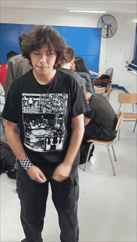 a boy wearing a black t-shirt with a picture of a stadium on it