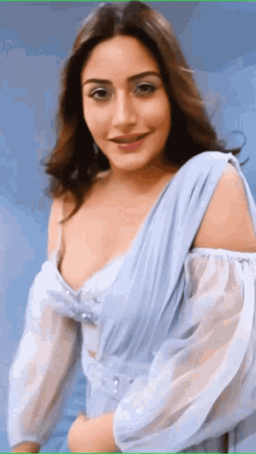 a woman in a light blue dress with a plunging neckline