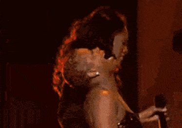 a woman in a red dress is dancing in front of a mirror in a room .