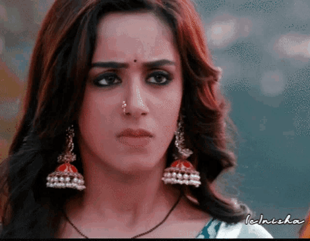 a close up of a woman wearing a nose ring and earrings with the name technisha written below her