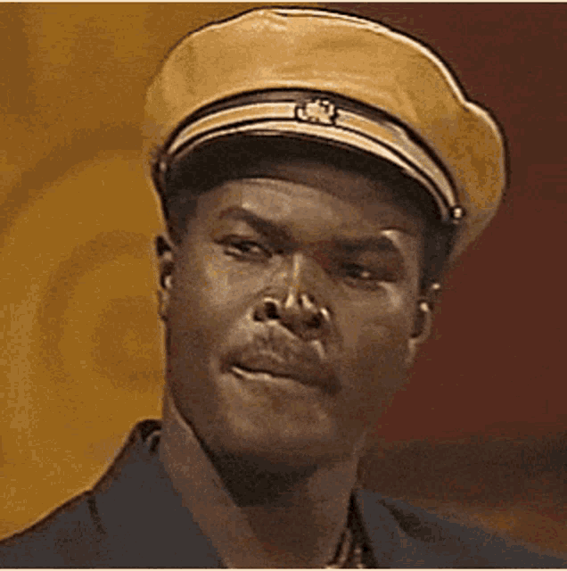 a man wearing a yellow hat and a blue shirt is making a funny face .