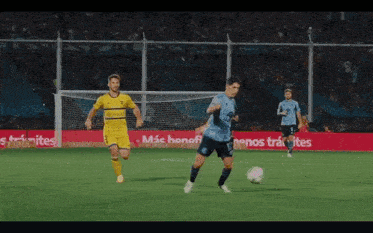 two soccer players on a field with a sign that says " mas beneficios "
