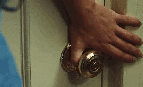 a close up of a person 's hand holding a door handle .