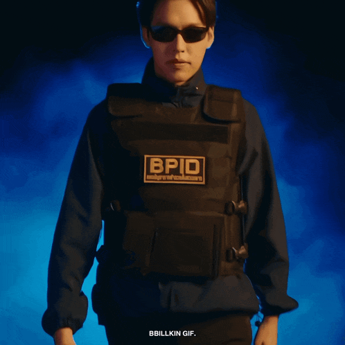 a man wearing sunglasses and a vest with bpid on it